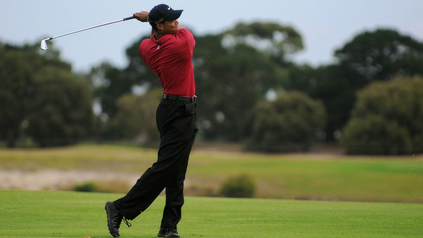 Tiger Woods plays a iron from the 17th fairway in his fourth round at the Emirates Australian Open at The Lakes golf course