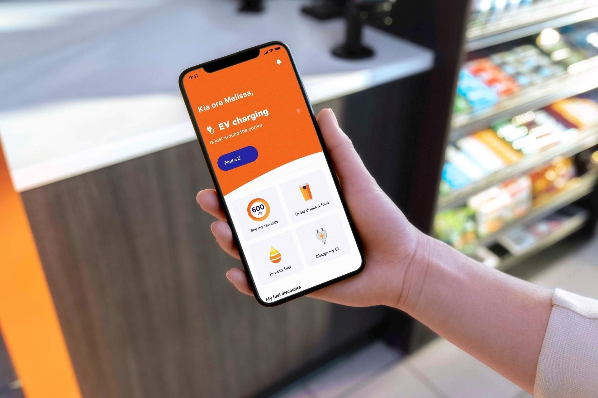 Customer using Z App to find EV charging and rewards options at a convenience store